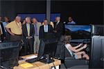 Ribbon cutting attendees observe a student learning on the new educational driving simulators.
